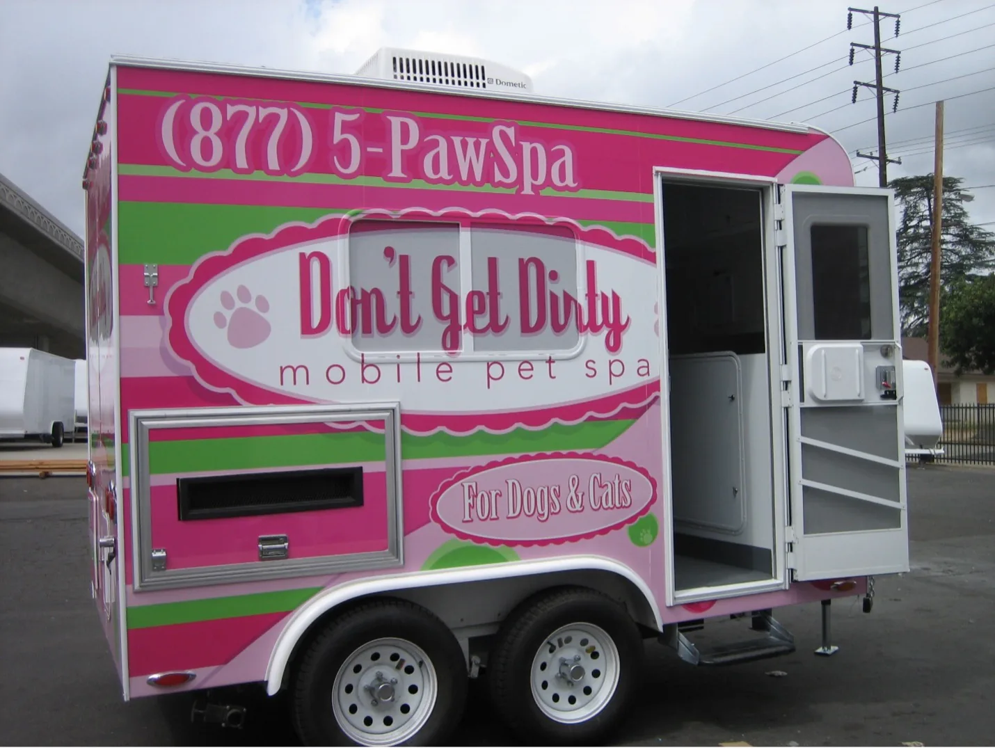 Brightly branded mobile pet grooming trailer