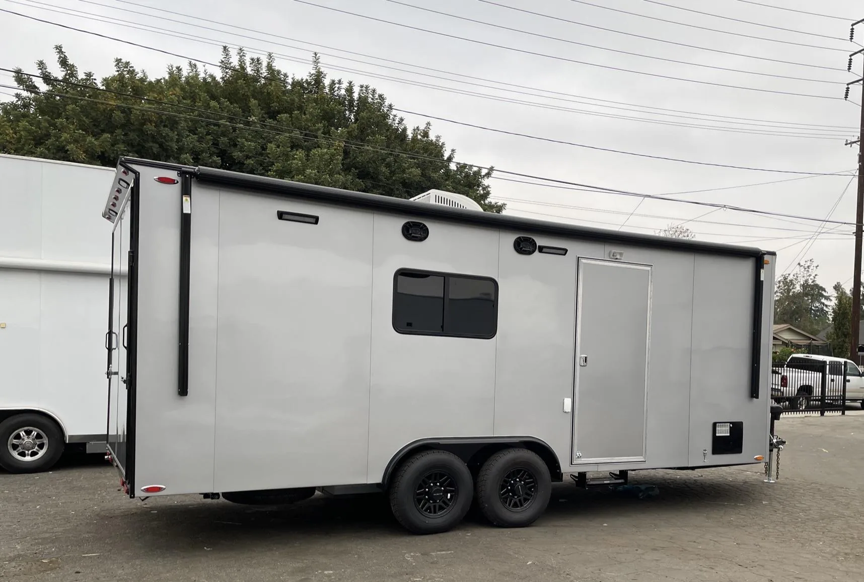 White tandem-axle enclosed trailer manufactured by Universal Trailers