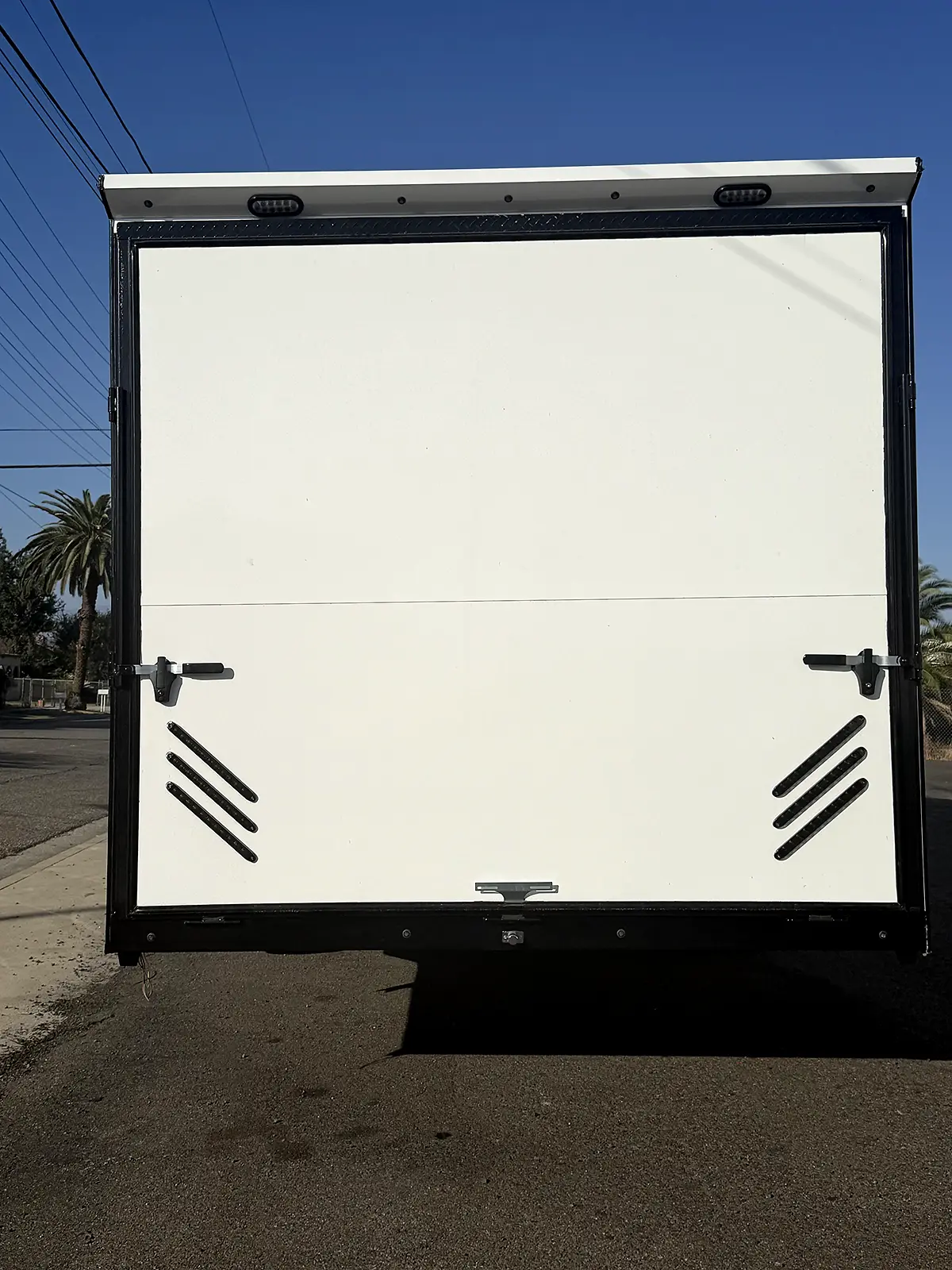 Rear view of the living quarters trailer with the ramp door closed